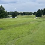 Panoramic view of a lush green golf course at Earlywine Golf Course. Smooth
