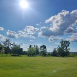 Panoramic view of a lush green golf course at Edelweiss Chalet Country Club. Smooth