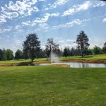 Panoramic view of a lush green golf course at Evergreen Golf Course. Smooth
