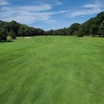 Panoramic view of a lush green golf course at Falmouth Country Club. Smooth