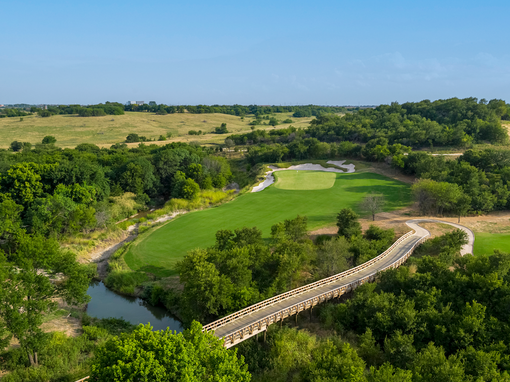 Panoramic view of a lush green golf course at Fields Ranch. Smooth