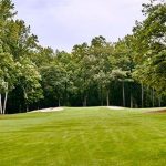 Panoramic view of a lush green golf course at Flat Creek Country Club. Smooth