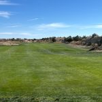 Panoramic view of a lush green golf course at Four Mile Ranch Golf Club. Smooth