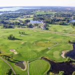 Panoramic view of a lush green golf course at Geneva Golf Club. Smooth