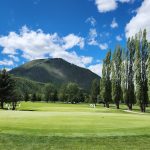 Panoramic view of a lush green golf course at Glacier View Golf Club. Smooth