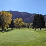 Panoramic view of a lush green golf course at Glenwood Springs Golf Club. Smooth