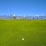 Panoramic view of a lush green golf course at Golf the Round. Smooth