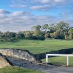 Panoramic view of a lush green golf course at Grand Cypress Golf. Smooth