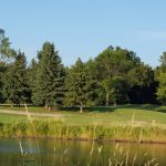 Panoramic view of a lush green golf course at Grand Forks Country Club. Smooth