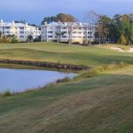 Panoramic view of a lush green golf course at Grande Dunes Resort Club. Smooth