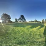 Panoramic view of a lush green golf course at Grayling Country Club. Smooth