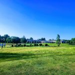 Panoramic view of a lush green golf course at Great Neck Country Club. Smooth