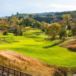 Panoramic view of a lush green golf course at Great River Golf Club. Smooth