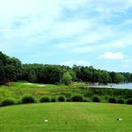 Panoramic view of a lush green golf course at Harbor Club on Lake Oconee. Smooth