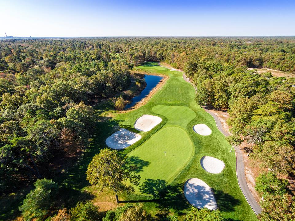 Panoramic view of a lush green golf course at Harbor Pines Golf Club. Smooth