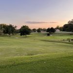 Panoramic view of a lush green golf course at Harrison Country Club. Smooth