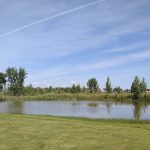 Panoramic view of a lush green golf course at Harvest Hills Golf Course. Smooth