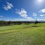 Panoramic view of a lush green golf course at Hawaii Country Club. Smooth