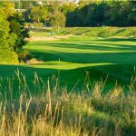 Panoramic view of a lush green golf course at Hawks Landing Golf Club. Smooth
