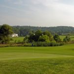Panoramic view of a lush green golf course at Heritage Creek Golf Club. Smooth