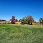 Panoramic view of a lush green golf course at Hidden Acres Golf Club. Smooth