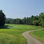 Panoramic view of a lush green golf course at Hidden Cove Golf Course. Smooth