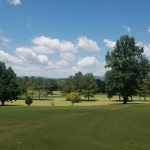 Panoramic view of a lush green golf course at Hidden Valley Golf. Smooth
