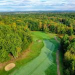 Panoramic view of a lush green golf course at Highland Green Golf Club. Smooth