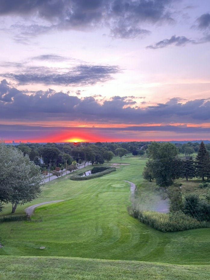 Panoramic view of a lush green golf course at Highland National Golf Course. Smooth