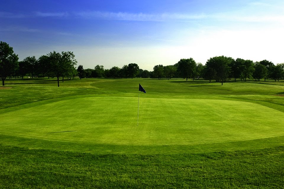 Panoramic view of a lush green golf course at Highland Woods Golf Course. Smooth