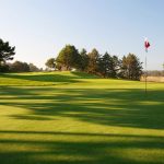 Panoramic view of a lush green golf course at Highlands Golf Club. Smooth
