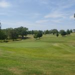 Panoramic view of a lush green golf course at Holiday Hills Golf Club. Smooth