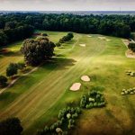 Panoramic view of a lush green golf course at Holly Ridge Golf Links. Smooth