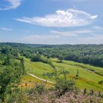 Panoramic view of a lush green golf course at Honey Creek Golf Club. Smooth