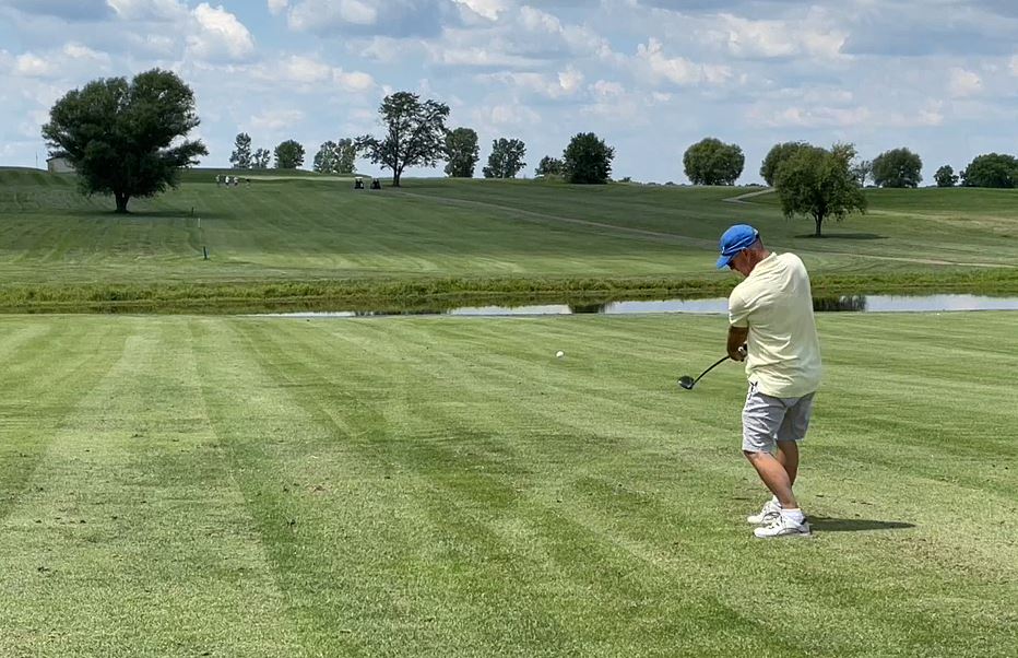 Panoramic view of a lush green golf course at Hoots Hollow. Smooth
