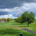 Panoramic view of a lush green golf course at Hop Brook Golf Course. Smooth