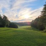 Panoramic view of a lush green golf course at Horse Creek Golf. Smooth