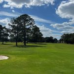Panoramic view of a lush green golf course at Houston Lake Country Club. Smooth