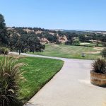 Panoramic view of a lush green golf course at Hunter Ranch Hole 1. Smooth