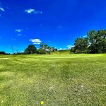 Panoramic view of a lush green golf course at Hunters Ridge Golf Course. Smooth