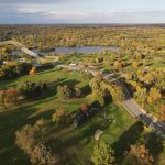 Panoramic view of a lush green golf course at Huron Hills Golf Course. Smooth