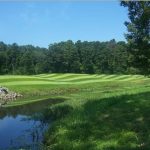 Panoramic view of a lush green golf course at Hurricane Golf Course. Smooth