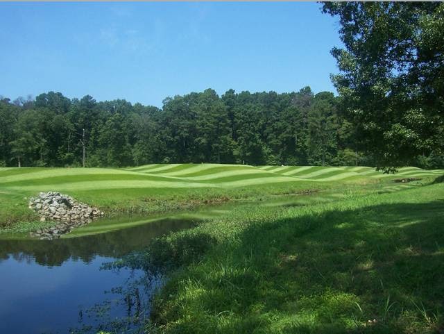 Panoramic view of a lush green golf course at Hurricane Golf Course. Smooth