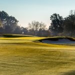 Panoramic view of a lush green golf course at Hurstbourne Country Club. Smooth
