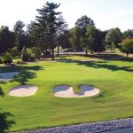 Panoramic view of a lush green golf course at Indian Hills Country Club. Smooth