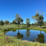 Panoramic view of a lush green golf course at Inness Golf. Smooth