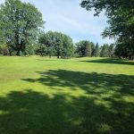Panoramic view of a lush green golf course at Interlochen Golf Course. Smooth