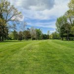 Panoramic view of a lush green golf course at J. E Good Park Golf Course. Smooth