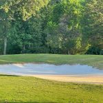 Panoramic view of a lush green golf course at Jackson National Golf Club. Smooth