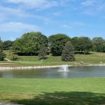 Panoramic view of a lush green golf course at Johnny Goodman Golf Course. Smooth